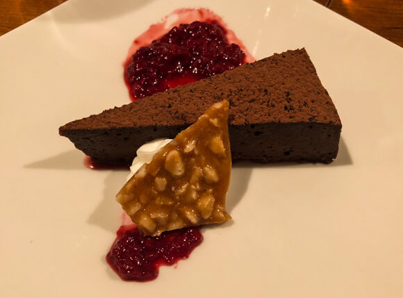Dark chocolate torte, fresh raspberry sauce and macadamia nut brittle