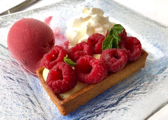Desert raspberry tart with whipped cream and sorbet