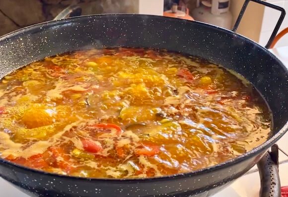 Vegetarain paella cooking in black pan