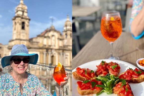 Woman sitting in front of cathedral having spritz and small plate of tomato appetizers.