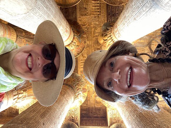 Two women looking down with columns above them.
