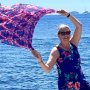 woman traveling solo with scarf in the air
