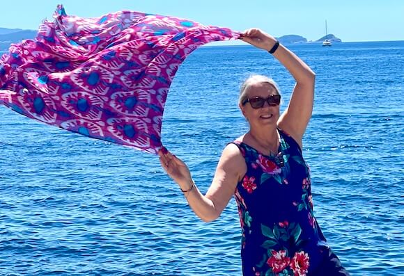 woman traveling solo with scarf in the air